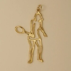 Peut inclure: Un pendentif en forme de joueur de tennis tenant une raquette. Le pendentif est en métal et a un design découpé.