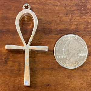May include: Silver Ankh pendant charm with a hammered finish. The pendant is about the size of a UK 20 pence coin.