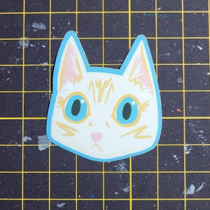 May include: A white cat with orange stripes and blue eyes. The cat is looking directly at the viewer. The cat's face is outlined in a light blue color.