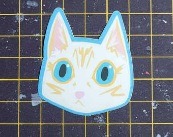 May include: A white cat with orange stripes and blue eyes. The cat is looking directly at the viewer. The cat's face is outlined in a light blue colour.