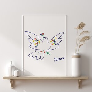 May include: A white dove with blue outline, decorated with colorful flowers, flies with wings outstretched. The dove is a line drawing by Pablo Picasso, with his signature below the dove.