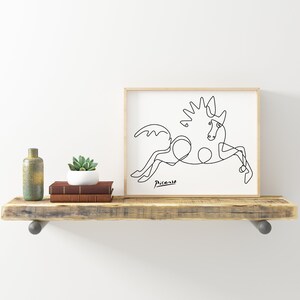 May include: A black and white line drawing of a horse, framed in a light wood frame. The drawing is signed "Picasso" in the bottom left corner.