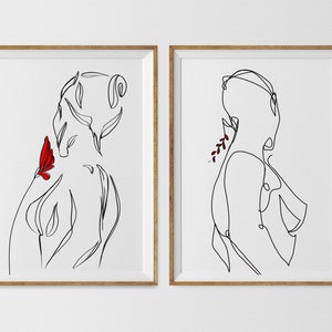 May include: Two framed line drawings of a person's body in black and white. The drawing on the left has a red butterfly on the shoulder. The drawing on the right has a red flower behind the ear.