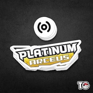 May include: A stack of white stickers with the text "PLATINUM ARCEUS" in black and yellow. The stickers are on a dark gray background.