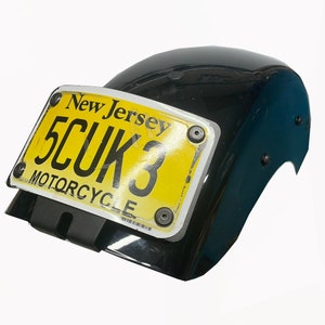 Pode incluir: Um pára-lama de motocicleta preto com uma placa de matrícula de motocicleta amarela de Nova Jersey que diz "5CUK3".
