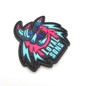 May include: Black and white patch with a pink and blue graphic of a horned creature with lightning bolts and the text "LOYAL SONS".