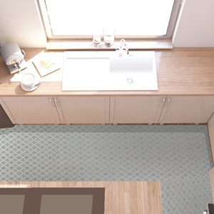 Könnte beinhalten: Eine Draufsicht auf eine Küche mit weißen Schränken, einem weißen Spülbecken und einer Arbeitsplatte aus Holz. Der Boden ist mit einem grauen und weißen geometrischen Muster gefliest.