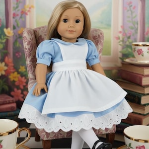 Peut inclure: Une poup&eacute;e aux longs cheveux blonds v&ecirc;tue d'une robe bleu clair &agrave; manches courtes bouffantes, d'un tablier blanc et d'une bordure en dentelle blanche &agrave; l'ourlet. La poup&eacute;e porte &eacute;galement des collants blancs et des chaussures noires &agrave; bride.