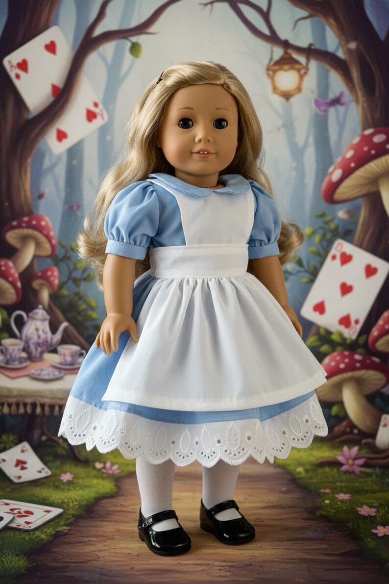 Peut inclure: Une poup&eacute;e aux longs cheveux blonds portant une robe bleu clair &agrave; manches courtes bouffantes, un tablier blanc avec une large ceinture et un ourlet en dentelle blanche. La poup&eacute;e porte &eacute;galement des collants blancs et des chaussures noires.