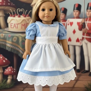 Peut inclure: Une poup&eacute;e aux longs cheveux blonds portant une robe bleu clair &agrave; manches courtes bouffantes, un tablier blanc et une bordure en dentelle blanche &agrave; l'ourlet. La poup&eacute;e porte &eacute;galement des collants blancs et des chaussures noires &agrave; bride.