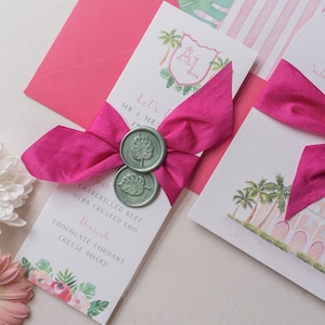 May include: A pink and white wedding menu with a pink ribbon tied around it. The menu has a green wax seal with a leaf design. The text on the menu reads "Let's Get Married", "Mr & Mrs", "29", "Char-grilled Beef", "Herb Crusted Cod", "Desserts", "Chocolate Fondant", and "Cheese Board".