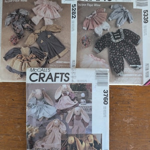 May include: Three McCall's Crafts sewing pattern envelopes by Faye Wine, numbered 5282, 5339, and 3760. The envelopes feature illustrations of handmade fabric rabbit dolls and various miniature clothing items including dresses, overalls, and shirts.
