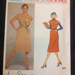 May include: Vogue American Designer sewing pattern number 1401 by Jerry Silverman. The pattern features two illustrations of women wearing dresses. The first woman is wearing a beige dress with a belt and the second woman is wearing a red dress with a blue beret.