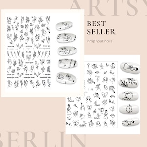May include: A sheet of black and white nail art stickers with various designs, including flowers, butterflies, faces, and abstract shapes. The stickers are labeled "F640" and "1119".