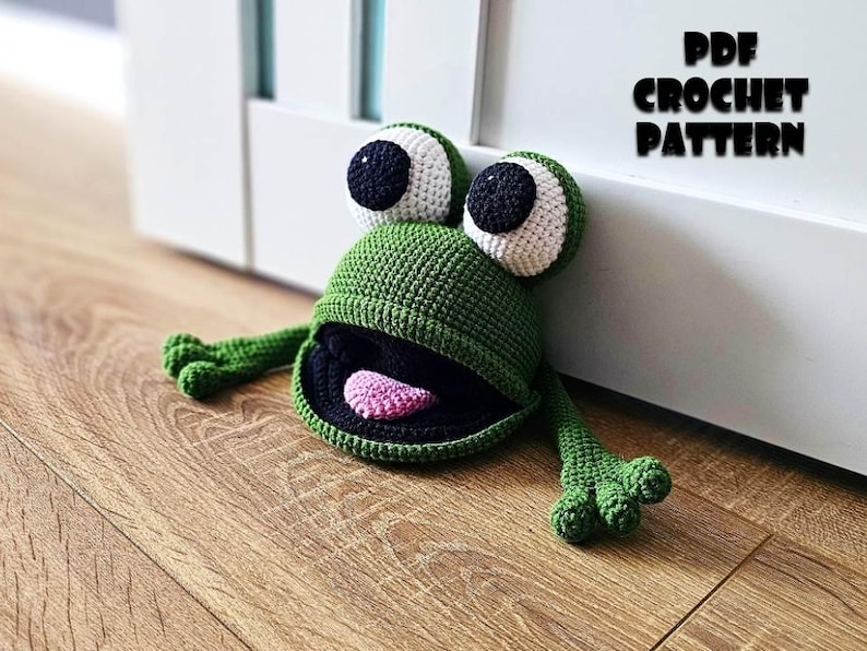 May include: Green crocheted frog doorstop with black eyes and a pink tongue.  PDF CROCHET PATTERN.