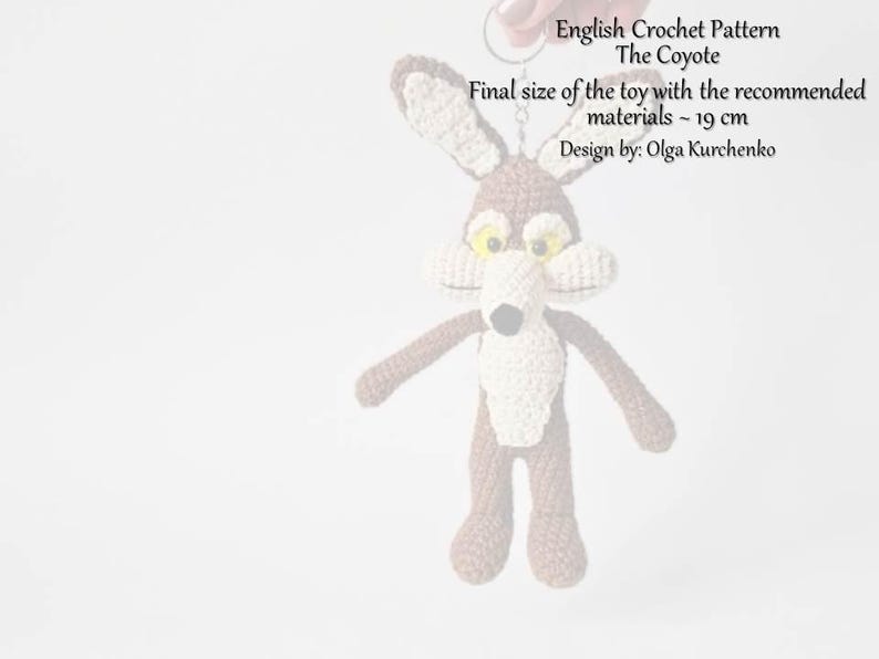 May include: A handmade crochet coyote toy, featuring brown and cream colors, with yellow eyes and a black nose. The toy is approximately 19 cm in size. The image includes text: "English Crochet Pattern The Coyote".
