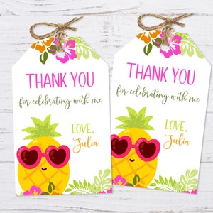 May include: Two white thank you tags with a pineapple wearing pink heart-shaped sunglasses and green leaves. The text on the tags reads "Thank you for celebrating with me" and "Love, Julia".
