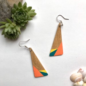 Orecchini ecologici in legno di quercia riciclato fatti a mano, dipinti a mano con un motivo geometrico in arancione, verde e giallo di Nui Jewellery