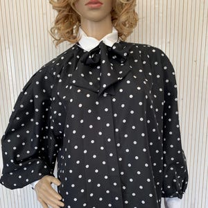 Blusa negra de mujer con lunares, mangas abullonadas y cuello vintage, talla 42, corte holgado.