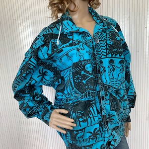 May include: A turquoise and black patterned jacket with a hood and pockets. The jacket features a tropical design with palm trees, skulls, and the word "DANGER". The jacket is buttoned up and has a drawstring hood.