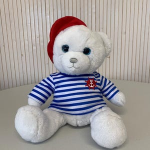 Vintage teddybeerknuffel in matrozenhemd en baret, jeugdherinnering, zigeunerstijl, schattige beer met blauwe ogen
