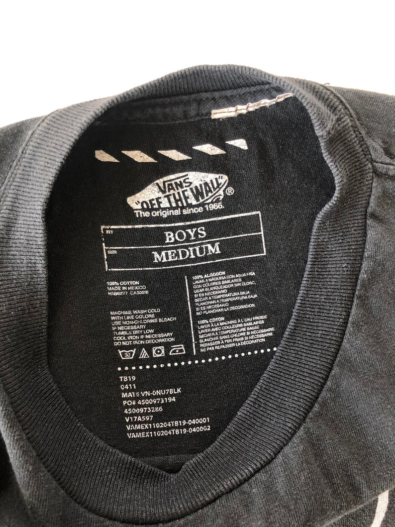 May include: Black t-shirt with a white Vans "Off The Wall" logo and care instructions. The t-shirt is labeled "Boys Medium" and has the text "The original since 1966."