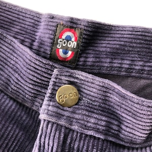 May include: Purple corduroy pants with a gold button and a label that says "goon" in a circle with red, white, and blue accents.