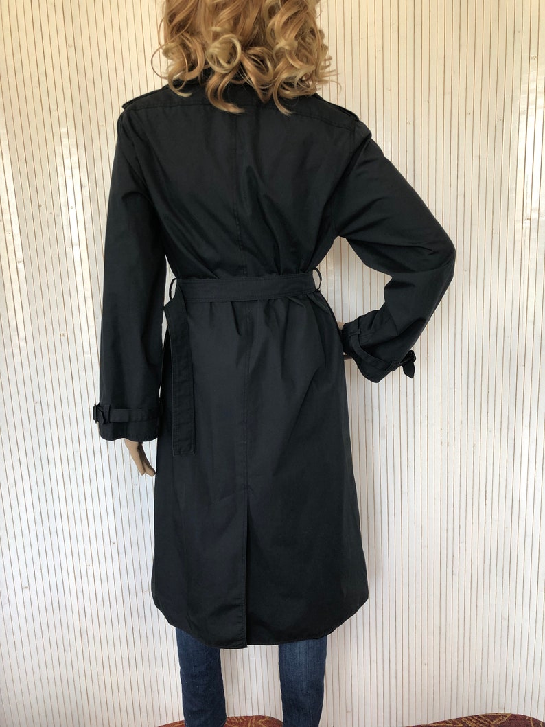 May include: A black long-sleeved trench coat with a belt. The coat has a classic design and is made of a durable fabric.