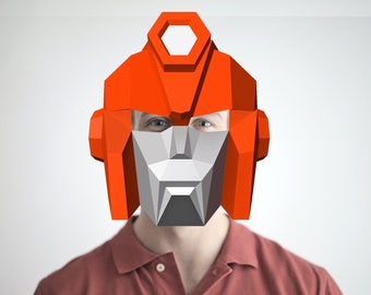 May include: A person wearing a red and gray robot mask. The mask is made of paper and has a geometric design.