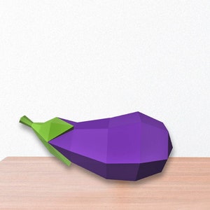 Puede incluir: Una berenjena geométrica morada con un tallo verde descansa sobre una superficie marrón claro. La berenjena es un diseño de baja poli, con superficies planas y angulares. El fondo es blanco.