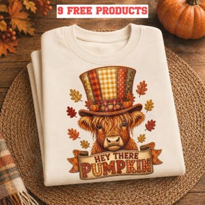 May include: A cream-coloured sweatshirt with a Highland cow wearing a patchwork top hat decorated with pumpkins and autumn leaves. The banner below the cow reads "HEY THERE PUMPKIN". The text "9 FREE PRODUCTS" is at the top.