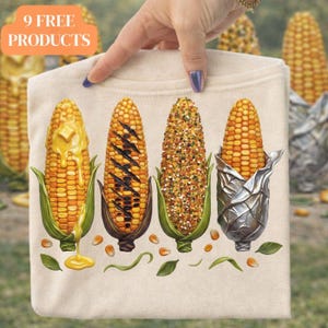 Puede incluir: Una camiseta color crema con cuatro ilustraciones detalladas de mazorcas de maíz, cada una preparada de manera diferente: con mantequilla, a la parrilla, sazonada y envuelta en papel de aluminio. El texto "9 FREE PRODUCTS" está en un cuadro naranja en la parte superior.