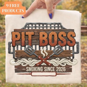 May include: A beige fabric with a "Pit Boss" design. The design features a wooden sign with the text "Pit Boss" in orange, crossed spatulas, and the phrase "Smoking Since 2026". An orange banner reads "9 FREE PRODUCTS".