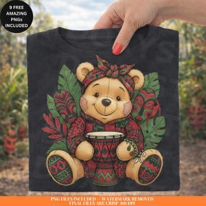 Op de afbeelding: Zwart t-shirt met een teddybeer met een rood-groen patroon outfit, hoofddoek en een trommel. De beer is omringd door groene bladeren. Tekst op het shirt luidt "9 FREE AMAZING PNGs INCLUDED".