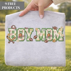 May include: A gray sweatshirt with the embroidered text "BOY MOM" in green, filled with sports ball patterns. The design includes baseballs, footballs, and basketballs. A baseball cap and crossed bats are also featured.