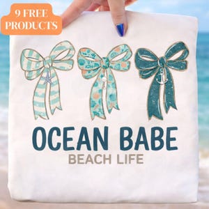 May include: White tote bag with three decorative bows in shades of blue and teal, featuring seashell and starfish designs. The text "OCEAN BABE BEACH LIFE" is printed below the bows. The top left corner has a label that says "9 FREE PRODUCTS".