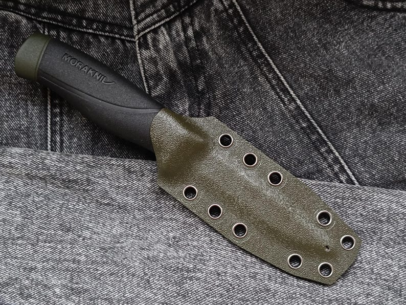 May include: A green leather knife sheath with multiple eyelets and the text "MORAKNII" on the handle.