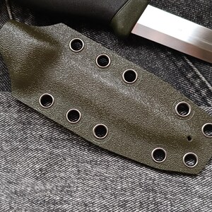 May include: A dark green leather knife sheath with multiple metal eyelets.