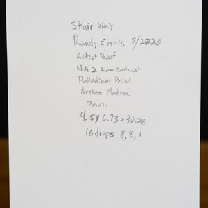 May include: A handwritten note on white paper with the title "Stair Way" and the artist's name "Randy Ennis". The note includes the date "7/2020", the words "Artist Proof", "NA 2 Low Contrast", "Palladium Print", "Arches Platine", "7 min", "4.5 x 6.73 = 30.28", and "16 drops 8, 8, 1".