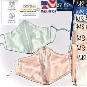 May include: Two silk face masks, one light green and one light pink, with adjustable ear loops. The masks are made of 100% pure 6A Momme Mulberry Silk and are OEKO-TEX® Standard 100 certified. The image also shows seven additional silk face masks in various colors, labeled MS #1 through MS #7.