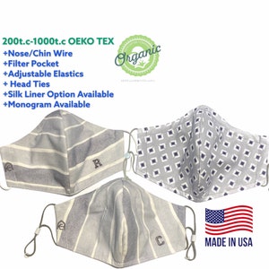 May include: Three gray and white striped fabric face masks with adjustable elastic ear loops. The masks have a nose wire, filter pocket, and head ties. The masks are made in the USA and are OEKO-TEX certified. The masks are organic cotton and have a silk liner option available. The masks are monogrammed with the letters R and C.