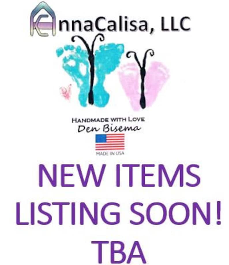 May include: A white background with a blue and pink butterfly design. The text "AnnaCalisa, LLC" is at the top of the image. The text "Handmade with Love Den Bisema" is in the middle of the image. The text "Made in USA" is below the text "Den Bisema". The text "NEW ITEMS LISTING SOON! TBA" is at the bottom of the image.