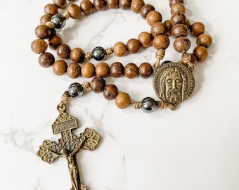 Catholic rosary made with brown robles wood beads, hematite beads, bronze tone Pardon crucifix, bronze tone Holy Face medal, and micro cord