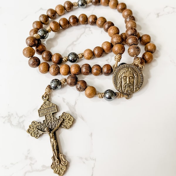 Catholic rosary made with brown robles wood beads, hematite beads, bronze tone Pardon crucifix, bronze tone Holy Face medal, and micro cord