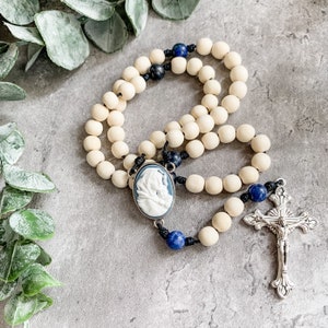 Catholic rosary with Madonna of the Streets blue cameo rosary center, white wood beads, sodalite gemstone beads, and micro cord