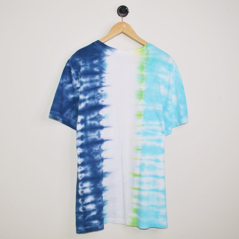 May include: A tie-dye t-shirt with a blue and green pattern. The shirt is white in the centre and has a blue and green tie-dye pattern on either side.