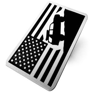 May include: A black and white metal car decal featuring an American flag design and a silhouette of a car driving over a cliff. The decal has a textured surface and is labelled "Urban Grey Black".