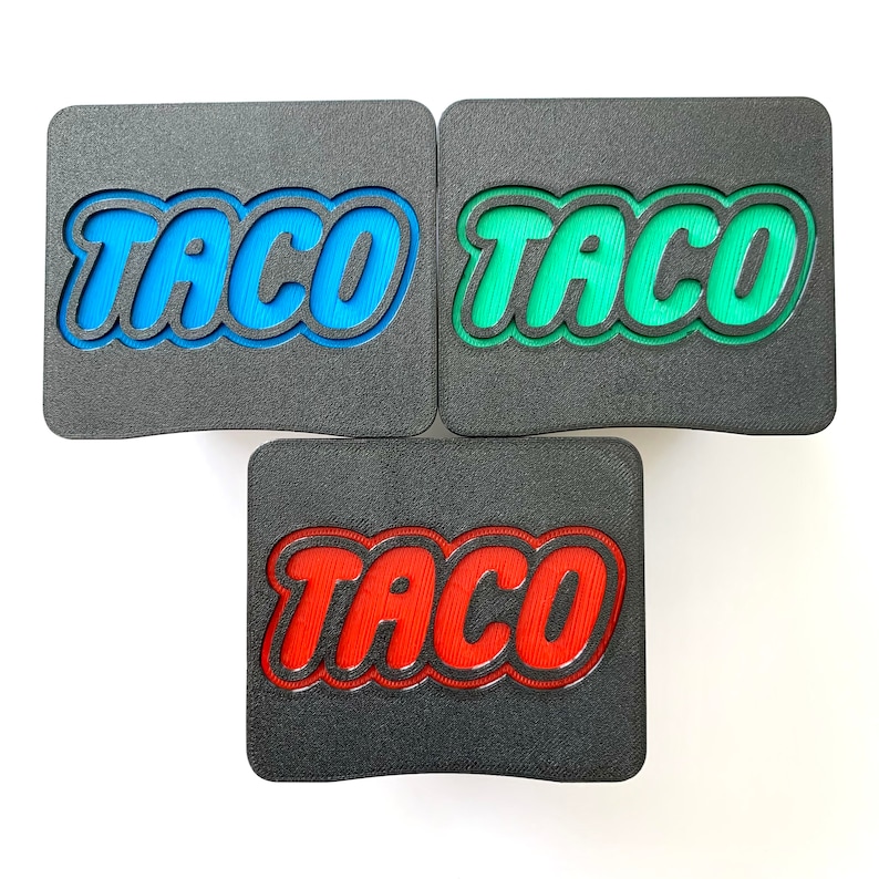 May include: Three black rectangular coasters with the word "TACO" in raised letters. The coasters are in blue, green, and red.