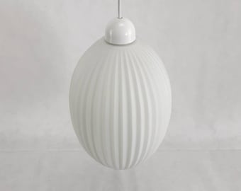 May include: White frosted glass pendant light fixture with a ribbed design. The light fixture is suspended from a white cord.
