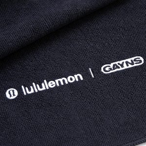Black embroidered towel featuring a bold white wordmark-style design, a striking high-contrast look suited to modern business branding.